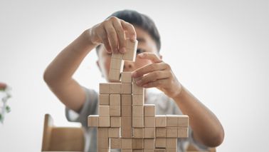 A boy playing with toy blocks.