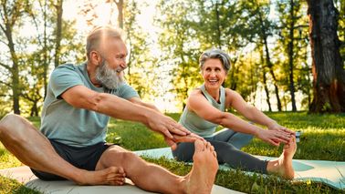retired man and woman doing yoga