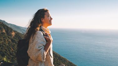 Seascape pursuit and mountain climbing for female tourist