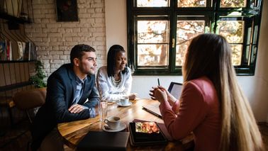 Young couple talking to financial advisor in their home