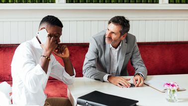 Businessmen discuss markets and economy between meetings in a modern coffee shop 