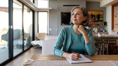 Woman brainstorms financial strategy with pen and paper