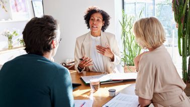 Financial advisor meeting with couple at table in modern home
