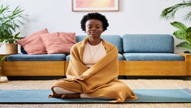 A woman meditating with a blanket