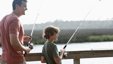 Dad fishing with son and wondering how tariffs will affect the economy.