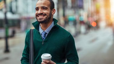 Businessman walking down the street with coffee