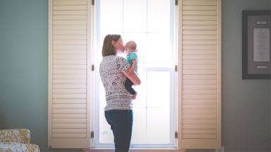 Mom holding baby wondering what her homeowner's insurance doesn't cover