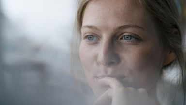 Woman with her finger or her mouth.