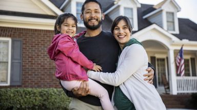 family in front of their home wondering about mortgage life insurance