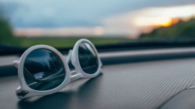 Sunglasses on a car dashboard after the driver hit the open road