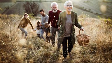 Senior woman with family climbing hill in dream retirement