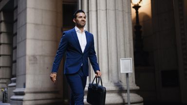 Professional businessman walking confidently with briefcase in city
