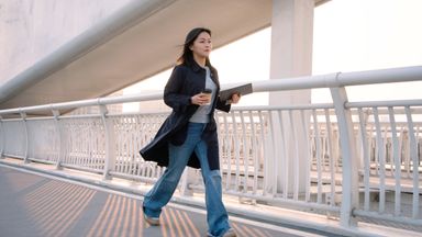Female walks while having coffee in the city