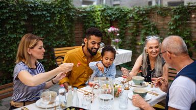 Multigenerational family enjoys a meal while discussing a spendthrift trust to leave an inheritance to loved ones.