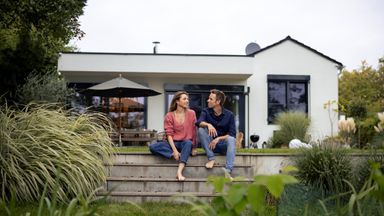 couple sitting outside their house.