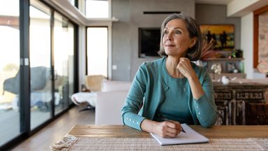 Woman brainstorms financial strategy with pen and paper