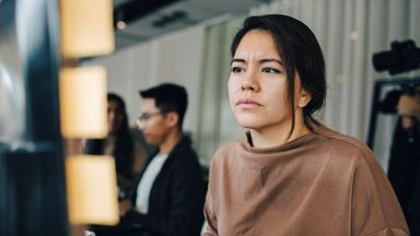 Investor looking at performance graph as she thinks about how tariffs and uncertainty are affecting her portfolio.