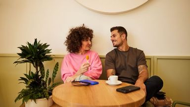 Couple sitting in a coffee shop smiling