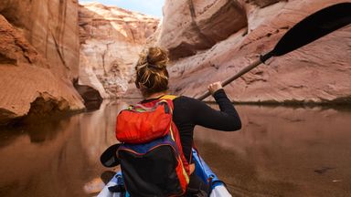 Woman kayaking and enjoying her financial freedom by maintaining a diversified portfolio with Northwestern Mutual Wealth Management Company
