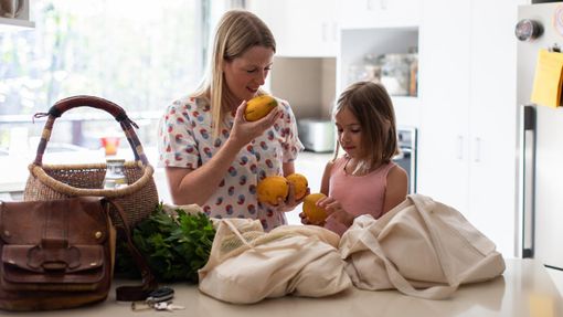 mother and daughter unpacking groceries