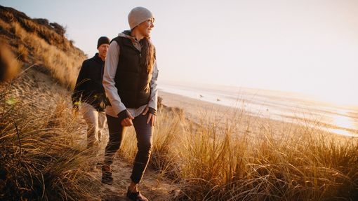 Couple hiking near the beach thinking about how much an average retirement costs.