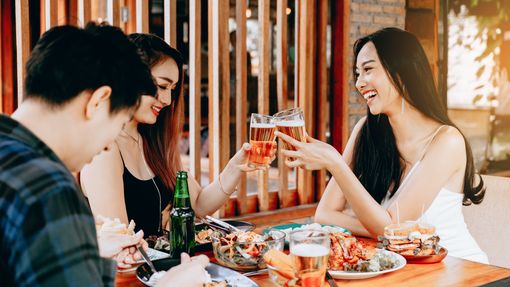 Friends eating at a restaurant as they celebrate getting a bonus.