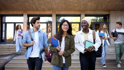 Students walking out of school, talking and laughing.