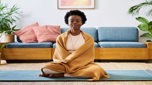 A woman meditating with a blanket