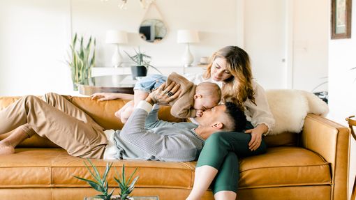  Couple relaxing on a sofa with baby
