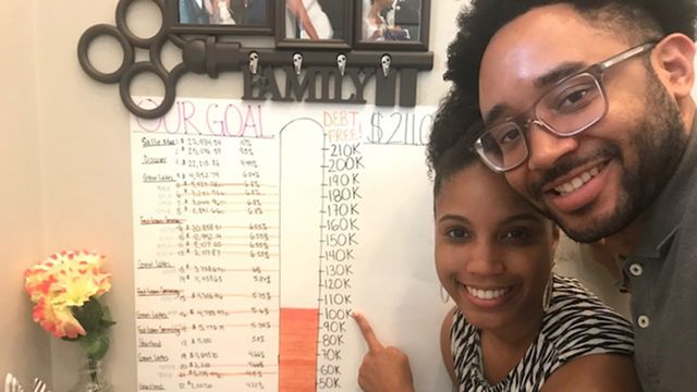 Faith and Leo Jean-Louis with their chart showing their debt payoff progress.