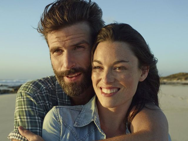 Couple embracing on the beach thinking about financial planning in your 30s. 