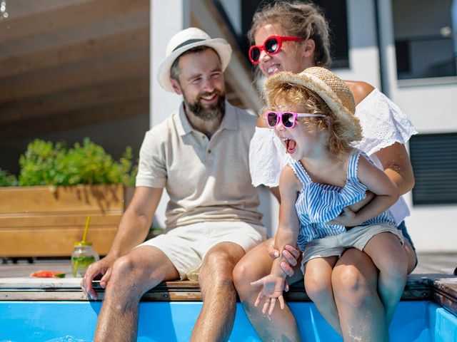 Happy family by pool considering financial planning in 40s