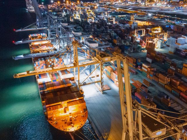 Cargo ship being unloaded in a harbor.