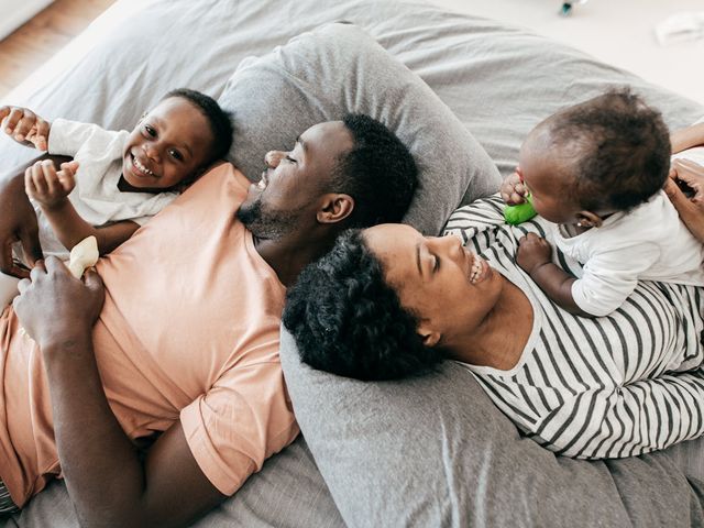 Couple lying on a bed with their kids