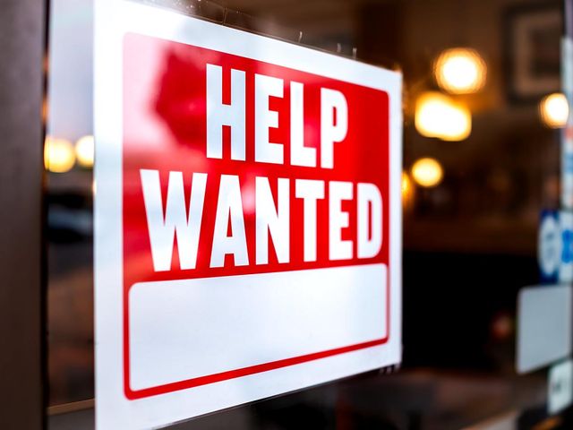 Help wanted sign in store window.