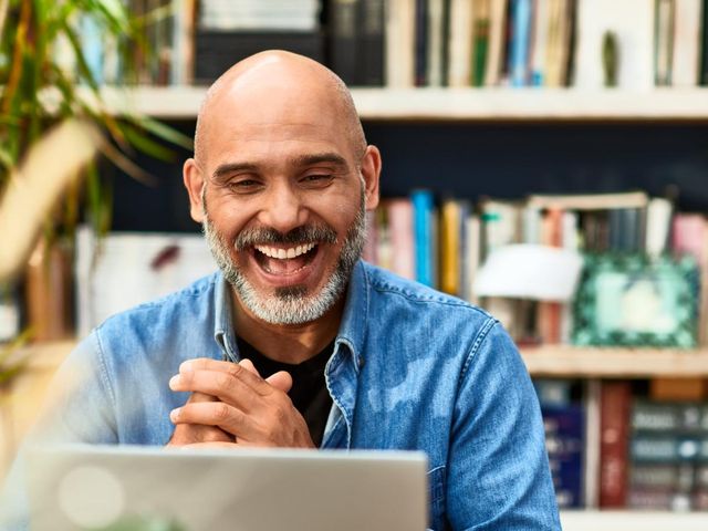 Man looking at a laptop and smiling