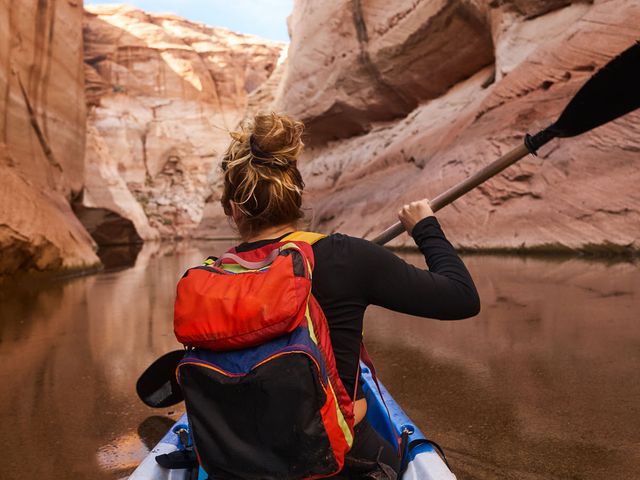 Woman kayaking and enjoying her financial freedom by maintaining a diversified portfolio with Northwestern Mutual Wealth Management Company