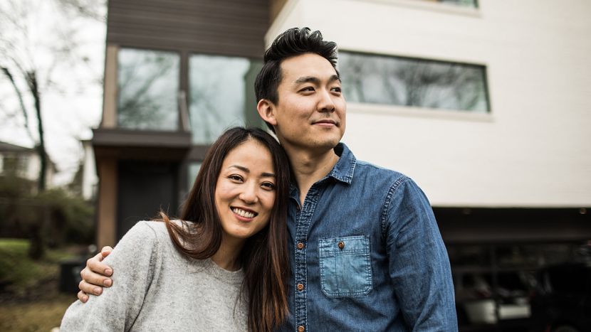 Couple outside a home thinking about converting their life insurance.