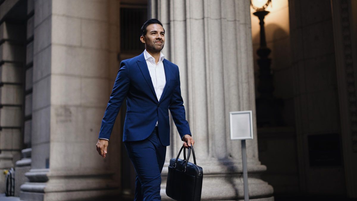 Professional businessman walking confidently with briefcase in city
