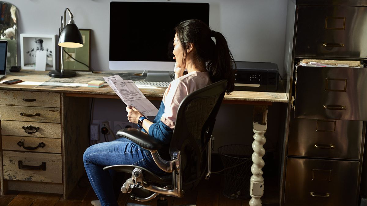 woman reviews her bank statements at her desk