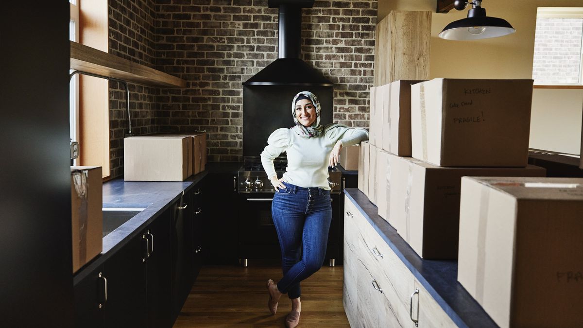 Woman standing in a kitchen in a home she bought in cash.