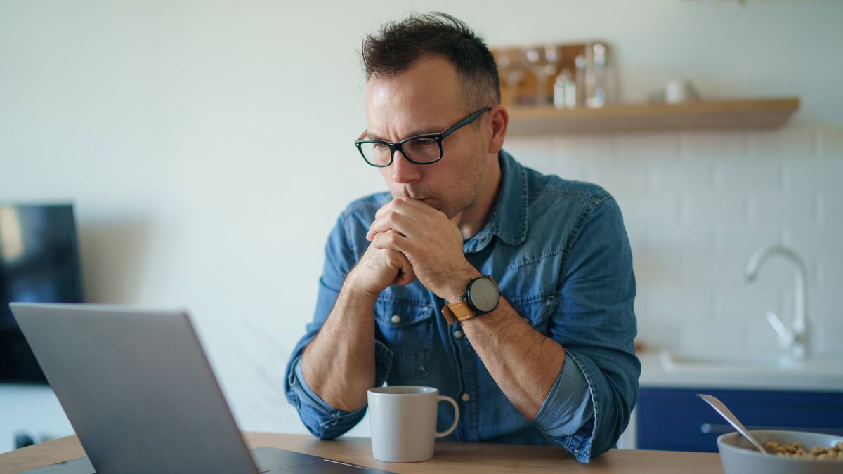 Man looking at laptop worrying about bond market volatility