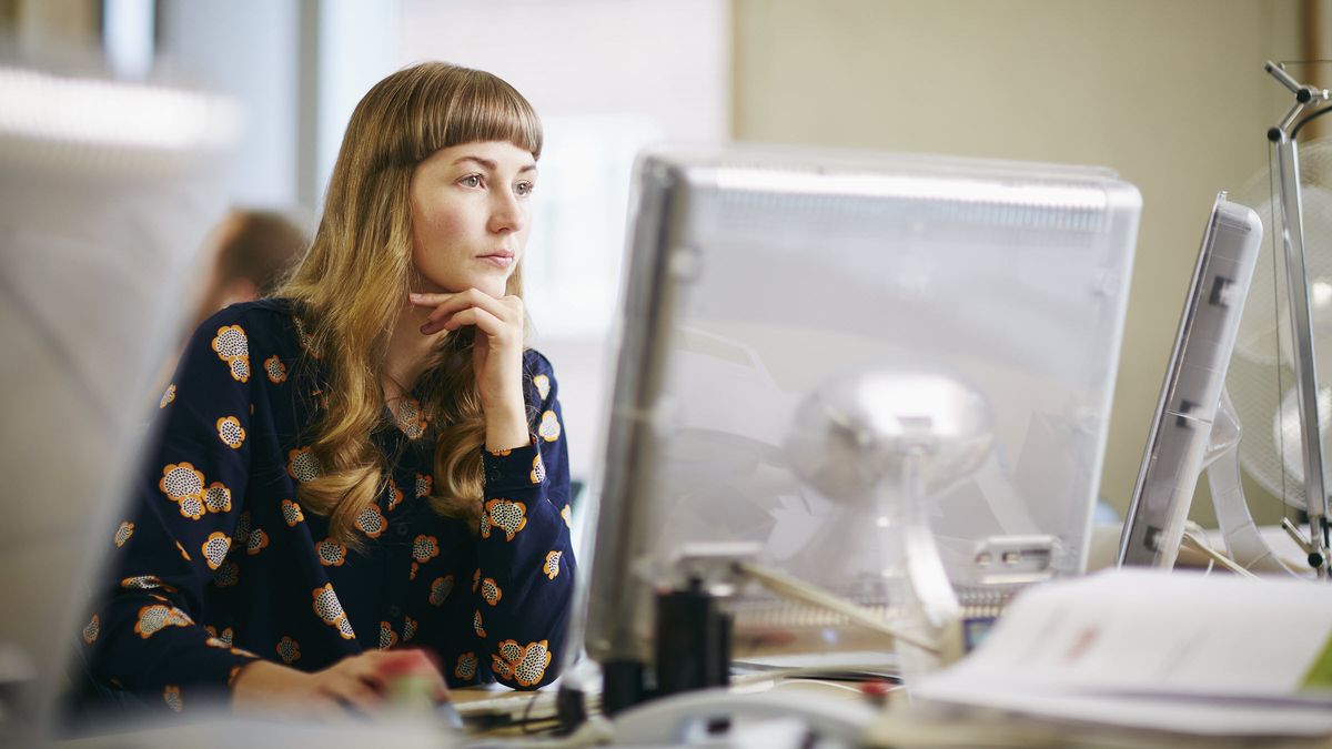 Woman looking at computer screens reading Northwestern Mutual Market Commentary