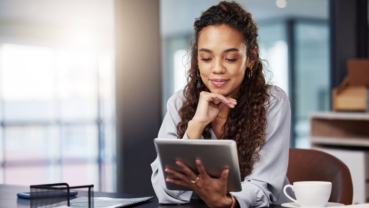 Woman looking at a tablet and learning about investing in your 20s