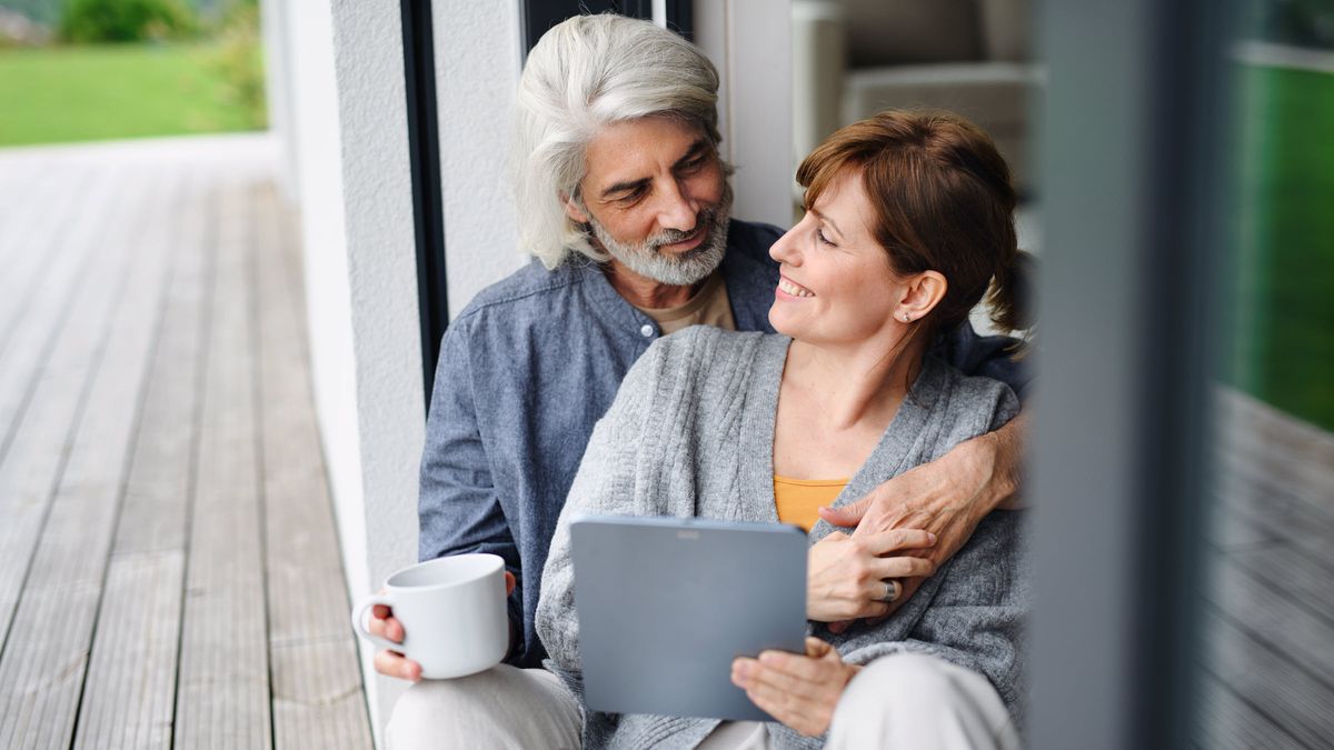 Couple sitting on a porch looking at each other and discussing fixed income investments.