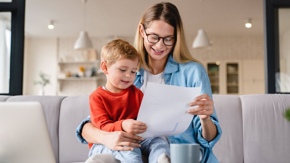 Mom with her son on a couch at home while researching a UGMA account 