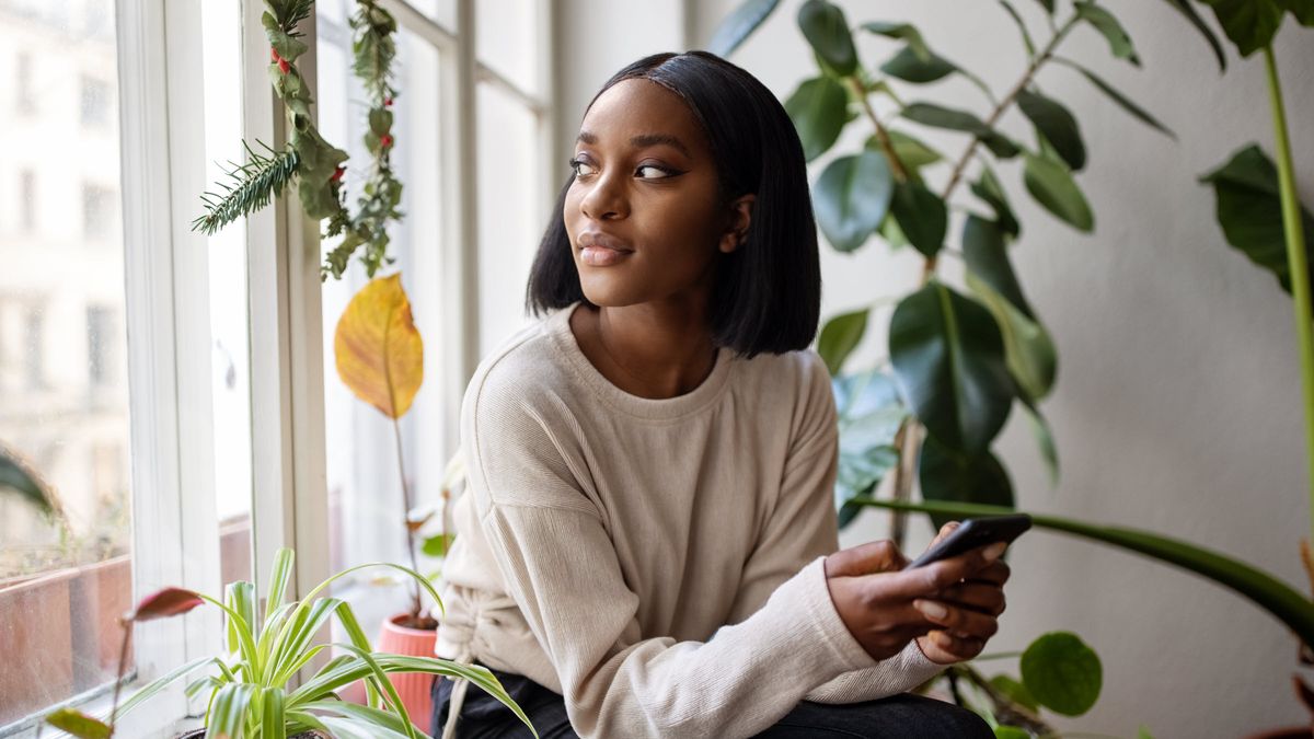 Woman looking out the window thinking about a savings account.