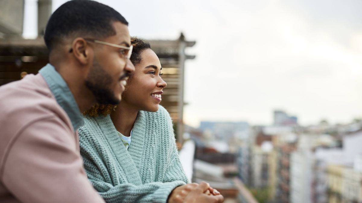 Couple looking into the distance from a balcony.