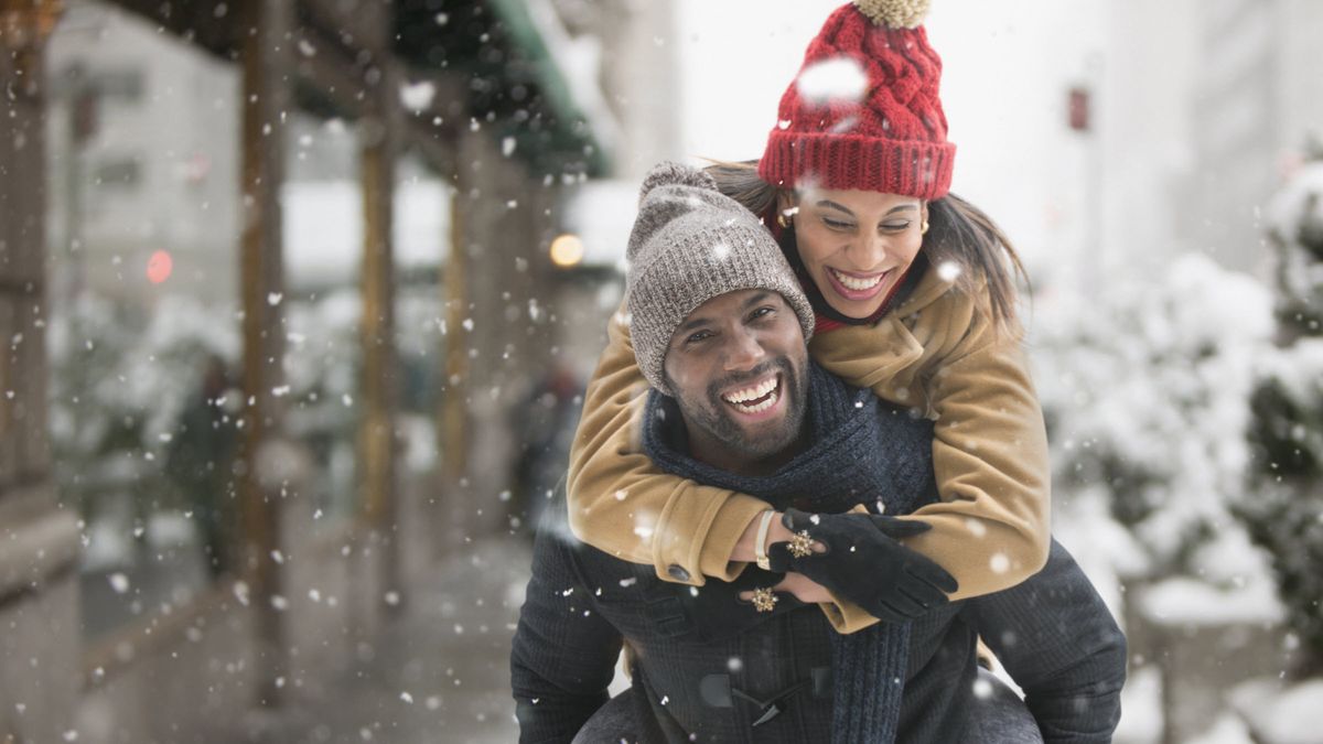 Couple on a sidewalk while it’s snowing thinking about how to improve their finances in January