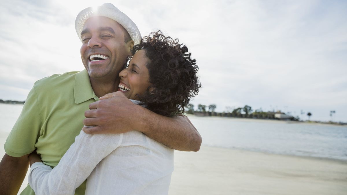 Happy couple on the beach investing in their relationship for a happy, healthy, long life together. 